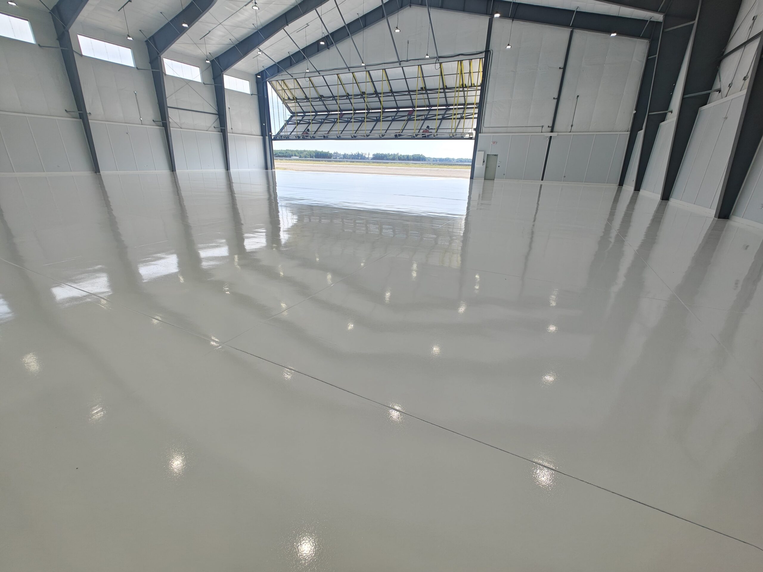 Hanger - 15,000 sq ft of white epoxy with aliphatic urethane top coat at Sanford Seacoast Regional Airport Commercial Flooring-min