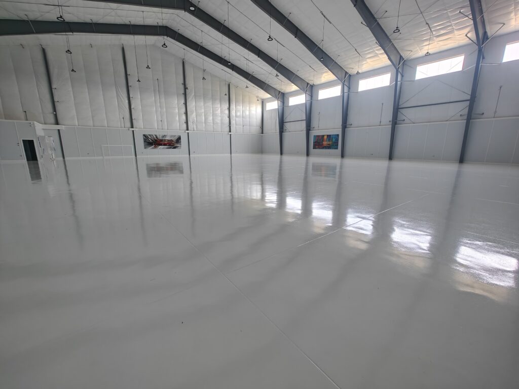 Hanger - 15,000 sq ft of white epoxy with aliphatic urethane top coat at Sanford Seacoast Regional Airport Epoxy Flooring-min